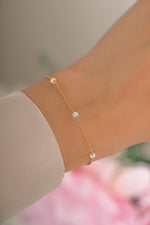 Gold opal beaded bracelet by Sami Jewels, featuring round opal beads and a delicate clasp, worn on a model's wrist.