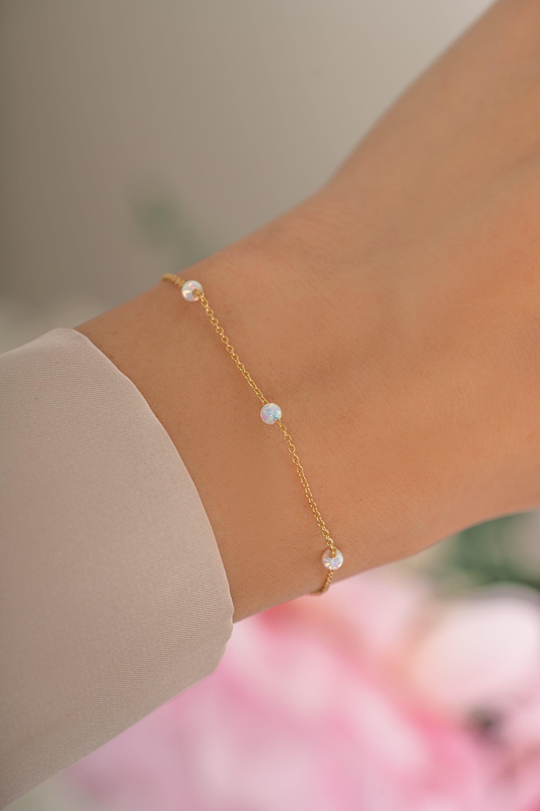 Gold opal beaded bracelet by Sami Jewels, featuring round opal beads and a delicate clasp, worn on a model's wrist.