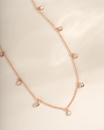 Close-up of Sami Jewels Opal & CZ charm necklace in rose gold, showcasing the sparkling gemstone and intricate chain details.