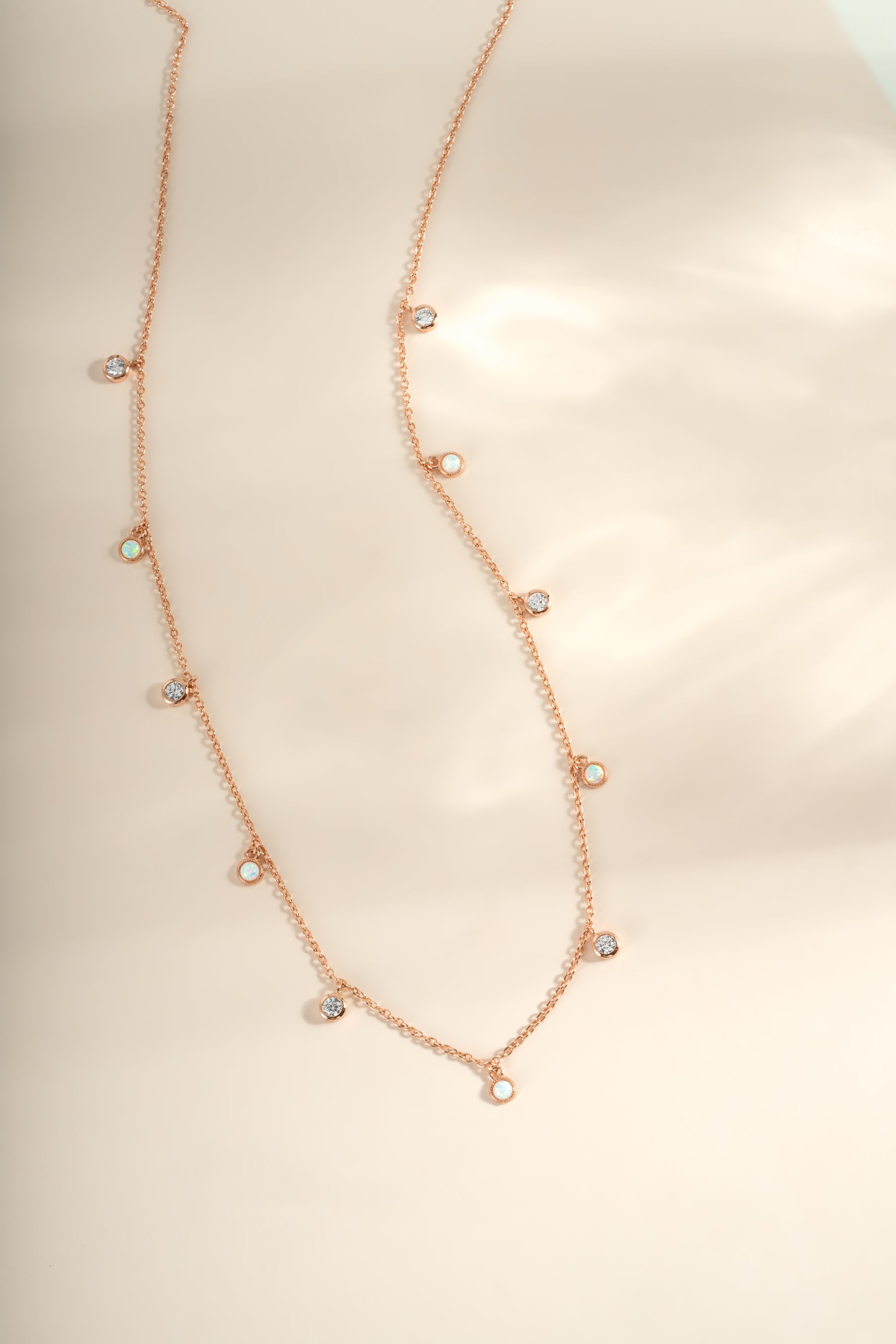 Rose gold Opal and cubic zirconia charm necklace from Sami Jewels showing the delicate pendant with sparkling stones.