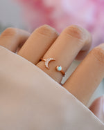 Rose gold Opal and CZ moon ring from Samijewels-527 worn on a model's finger, showcasing a celestial-inspired design.