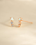 Rose gold opal ear climber earrings by Sami Jewels, featuring sparkling opal stones and elegant curved design.