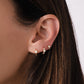 Close up image of model wearing three dainty tiny huggie earrings. The first piercing is a solitaire opal stone dainty earrings, the second piercing is a cz studded gold and opal baby hoop earring, and the last piercing is a aesthetic opal stud earring.