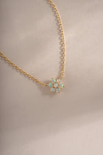 Close-up of Sami Jewels opal flower necklace featuring a gold chain and blooming flower design.