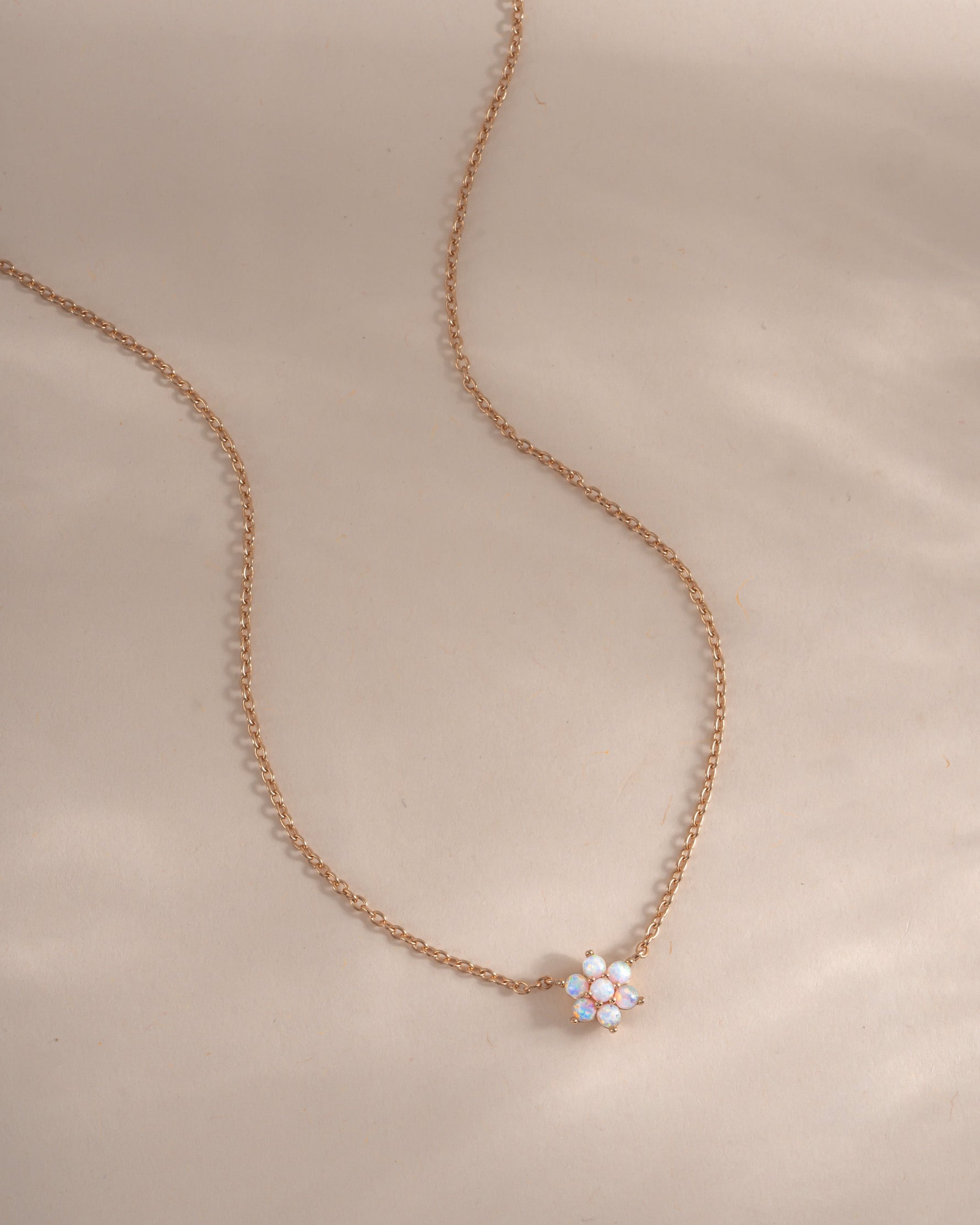 Rose gold opal flower necklace from Sami Jewels, featuring a delicate floral design and sparkling gemstone centerpiece.