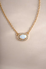 Gold opal halo necklace by Sami Jewels featuring a central opal stone surrounded by a delicate gold halo.