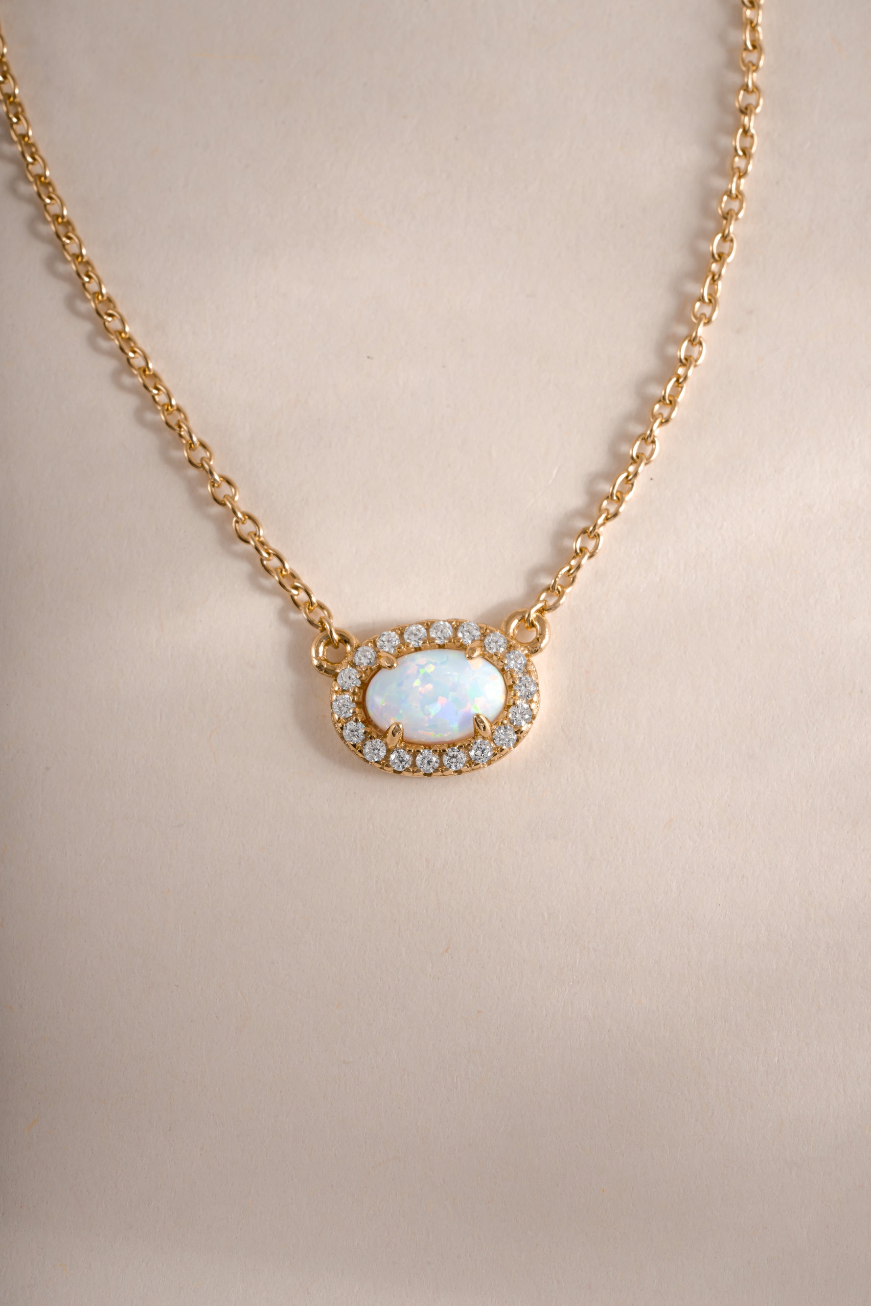 Gold opal halo necklace by Sami Jewels featuring a central opal stone surrounded by a delicate gold halo.