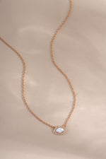 Rose gold Opal Halo Necklace by Sami Jewels with a central opal gemstone surrounded by a halo setting.