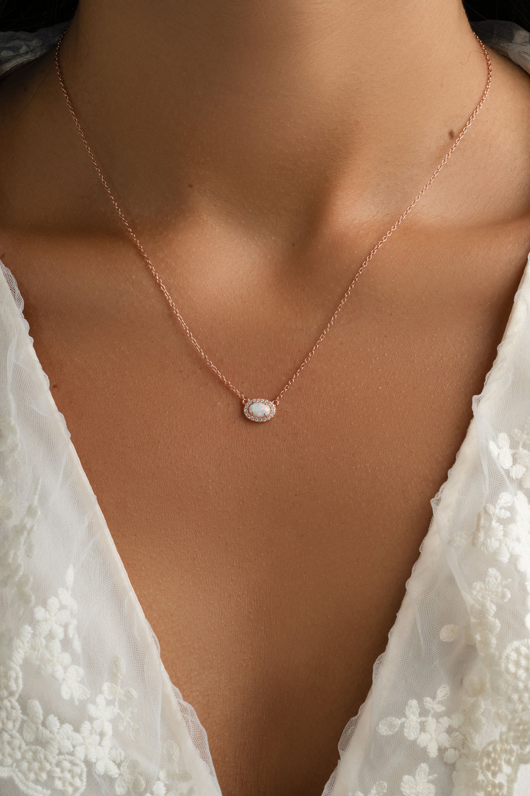 Sami Jewels opal halo necklace with a rose gold chain featuring a central opal gemstone surrounded by a halo setting.