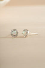 Sterling silver opal halo stud earrings by Sami Jewels featuring sparkling opal gemstones and a classic halo design.