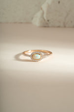 Sami Jewels Opal Halo Ring featuring a central opal gemstone surrounded by a gold halo setting, front view.