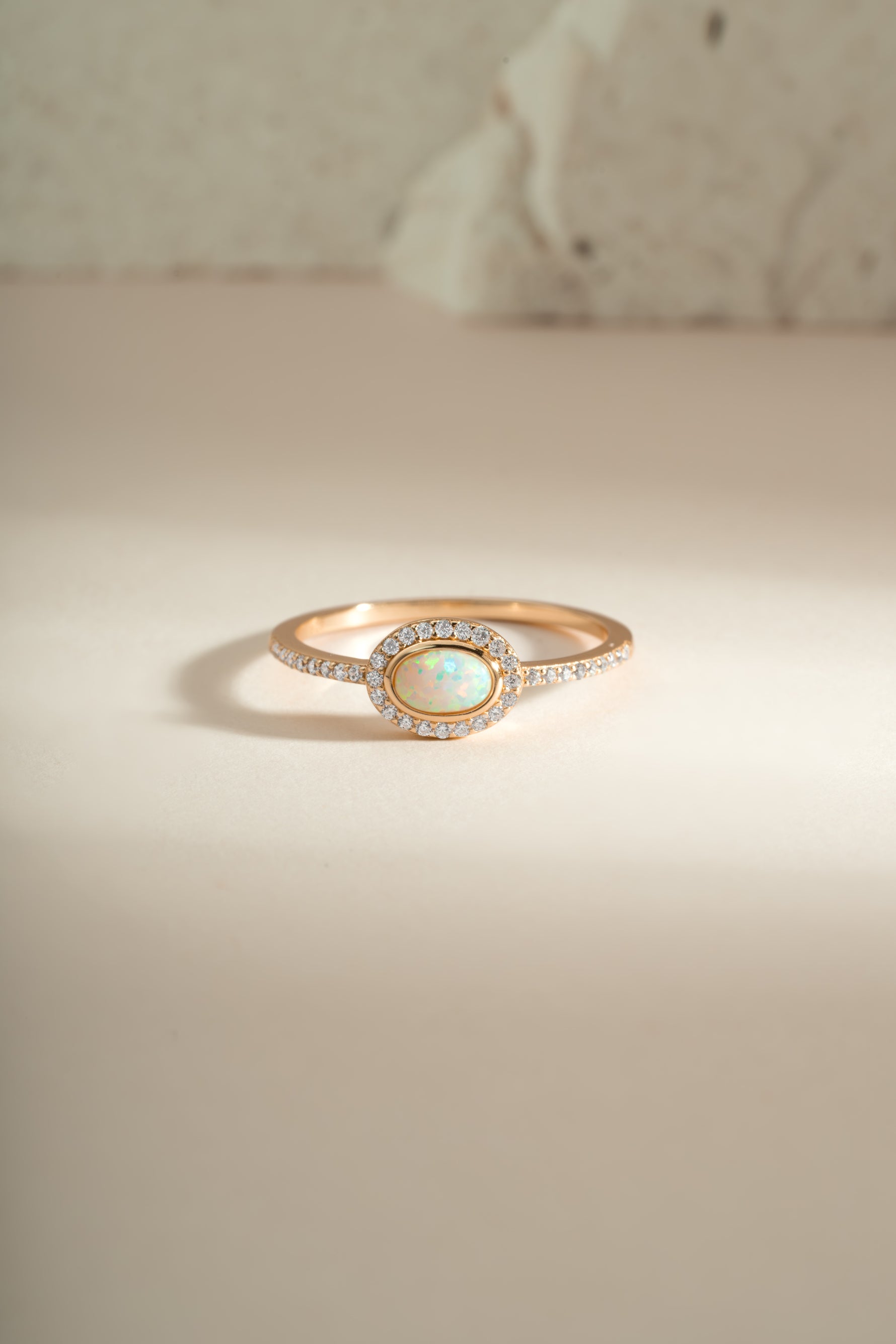 Sami Jewels Opal Halo Ring featuring a central opal gemstone surrounded by a gold halo setting, front view.