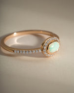 Sami Jewels opal halo ring with gold band, side view showing the shimmering opal centerpiece and detailed setting.