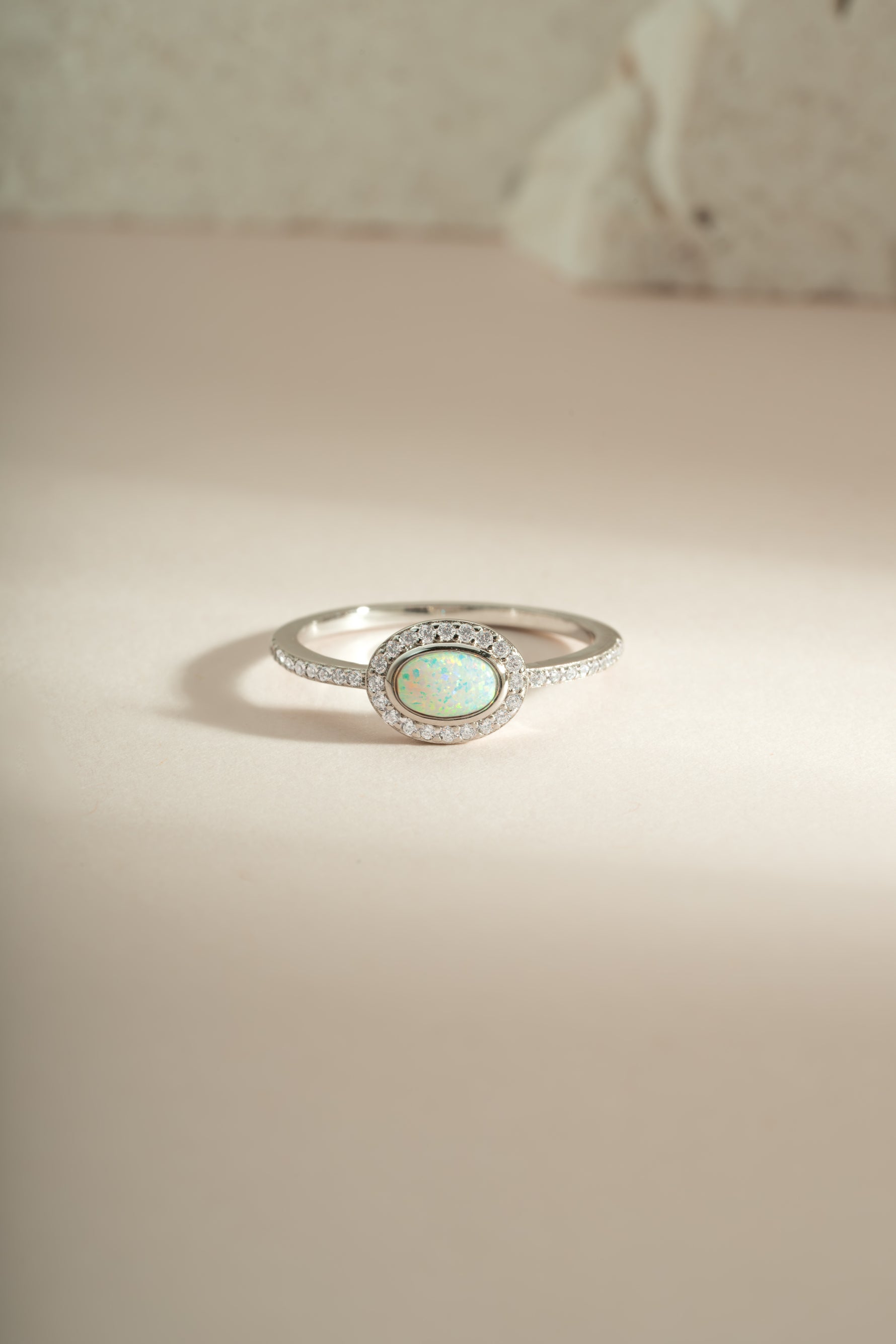 Sterling silver Opal Halo Ring by Sami Jewels featuring a vibrant opal gemstone surrounded by a silver halo design.