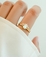 Gold opal ring set with pave ring from Sami Jewels, featuring multiple rings with sparkling opal stones on a model's hand.