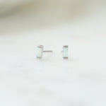 closeup image of silver stud earrings with opal gemstone 