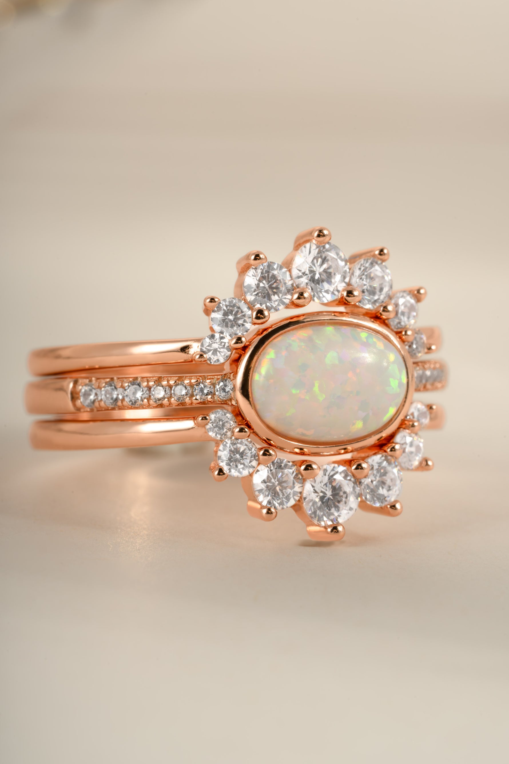 Set of three Sami Jewels opal rings with rose gold bands, featuring colorful opal stones, front view.