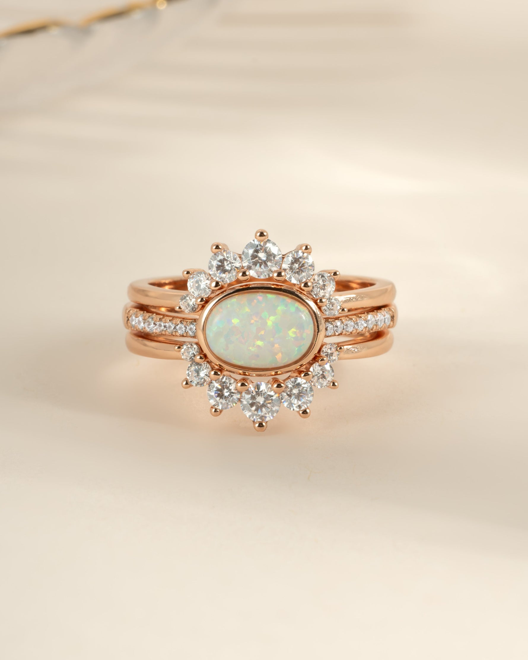 Three Sami Jewels opal rings set in rose gold with vibrant, colorful opal stones and delicate band designs.