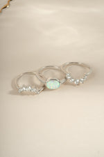 Set of three Sami Jewels opal rings with vibrant opal stones on a white background, showcasing elegant jewelry designs.