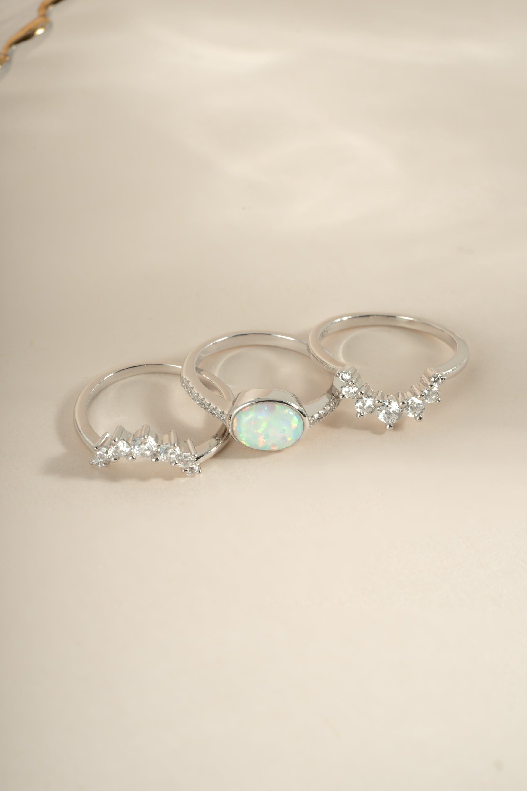 Set of three Sami Jewels opal rings with vibrant opal stones on a white background, showcasing elegant jewelry designs.