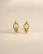 Gold embellished opal stud earrings by Sami Jewels, featuring round opals with decorative gold accents, front view.