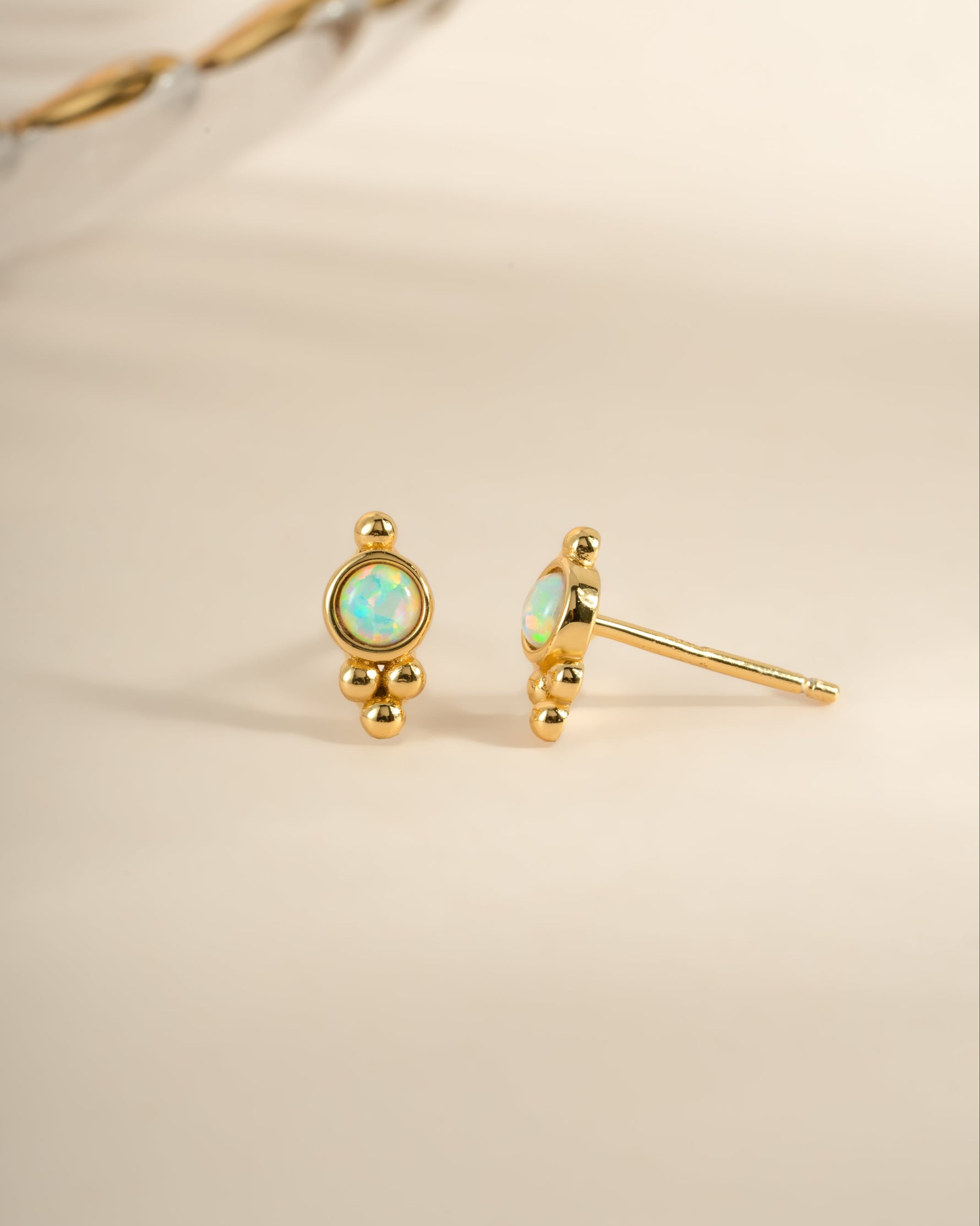 Gold embellished opal stud earrings by Sami Jewels featuring sparkling opal gemstones and delicate gold settings.