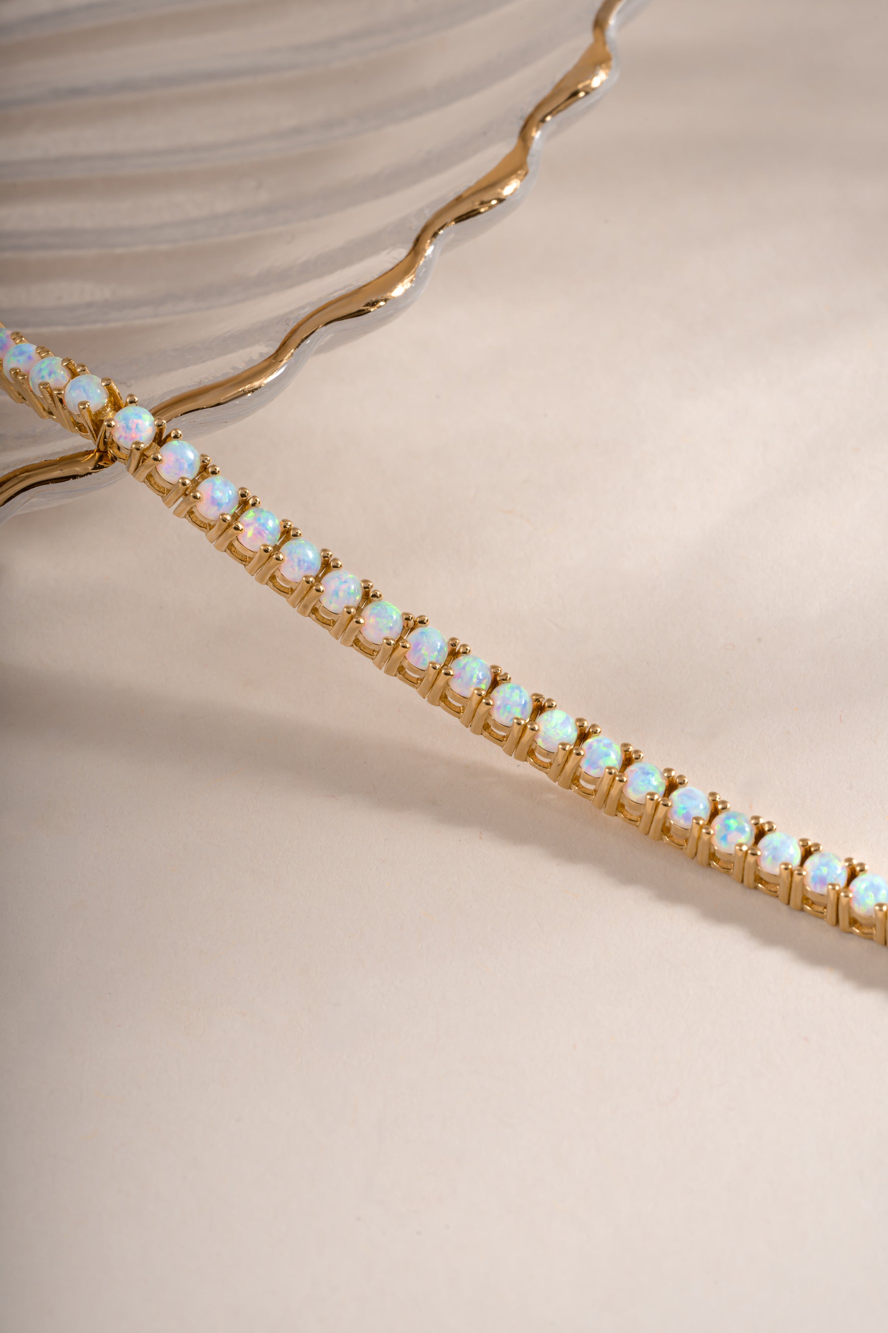 Close-up of Sami Jewels opal tennis bracelet with gold setting, featuring a row of shimmering opal gemstones.