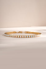Gold Opal Tennis Bracelet by Sami Jewels featuring a row of sparkling opal stones on a sleek gold chain.