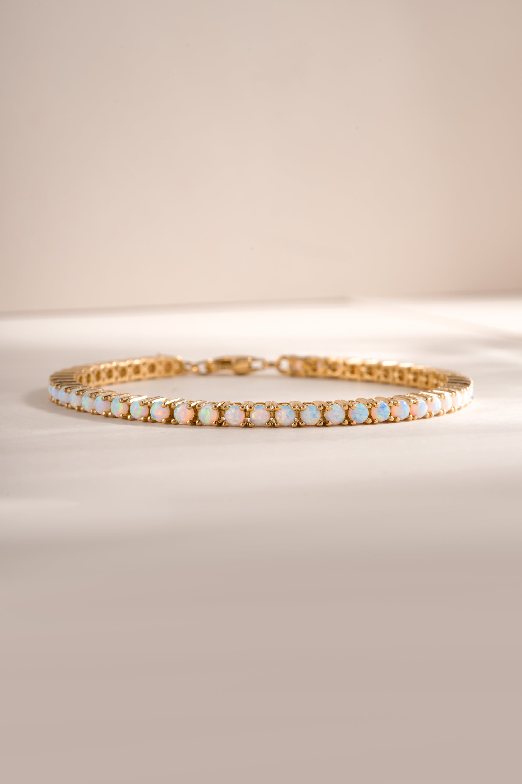 Gold Opal Tennis Bracelet by Sami Jewels featuring a row of sparkling opal stones on a sleek gold chain.