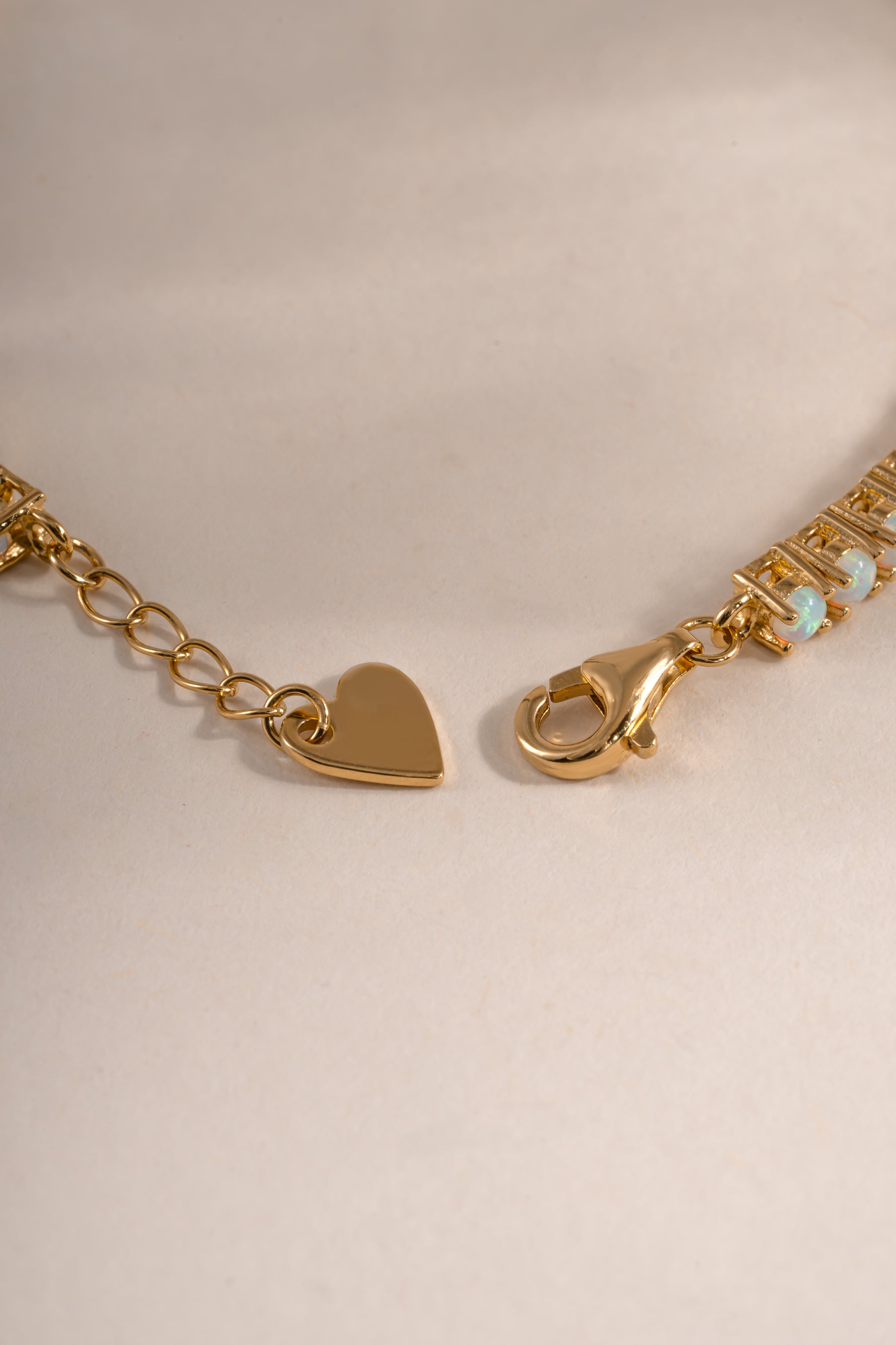 Sami Jewels opal tennis bracelet with gold setting and lobster clasp closure, featuring sparkling opal stones on a delicate bracelet chain.