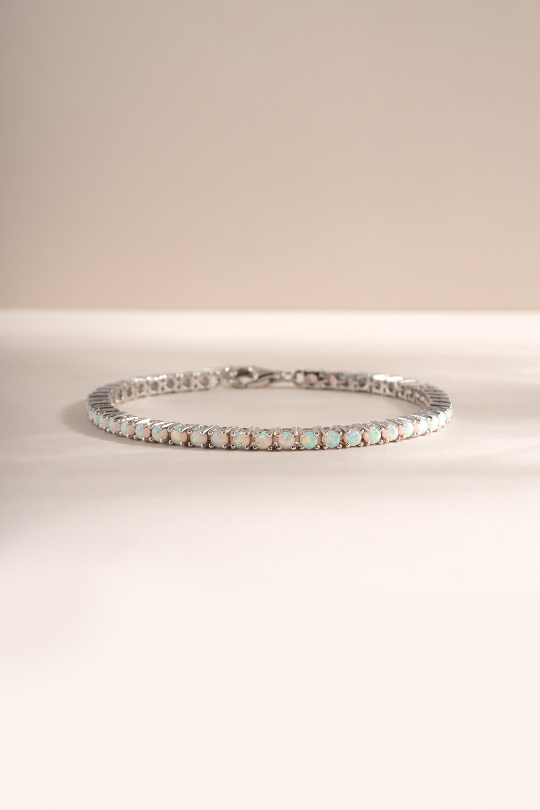 Silver opal tennis bracelet by Sami Jewels featuring a row of shimmering opal gemstones on a sleek bracelet design.