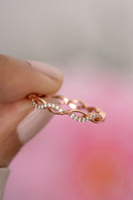 Close-up of Sami Jewels open infinity ring in rose gold, showcasing its delicate, continuous loop design on a plain background.