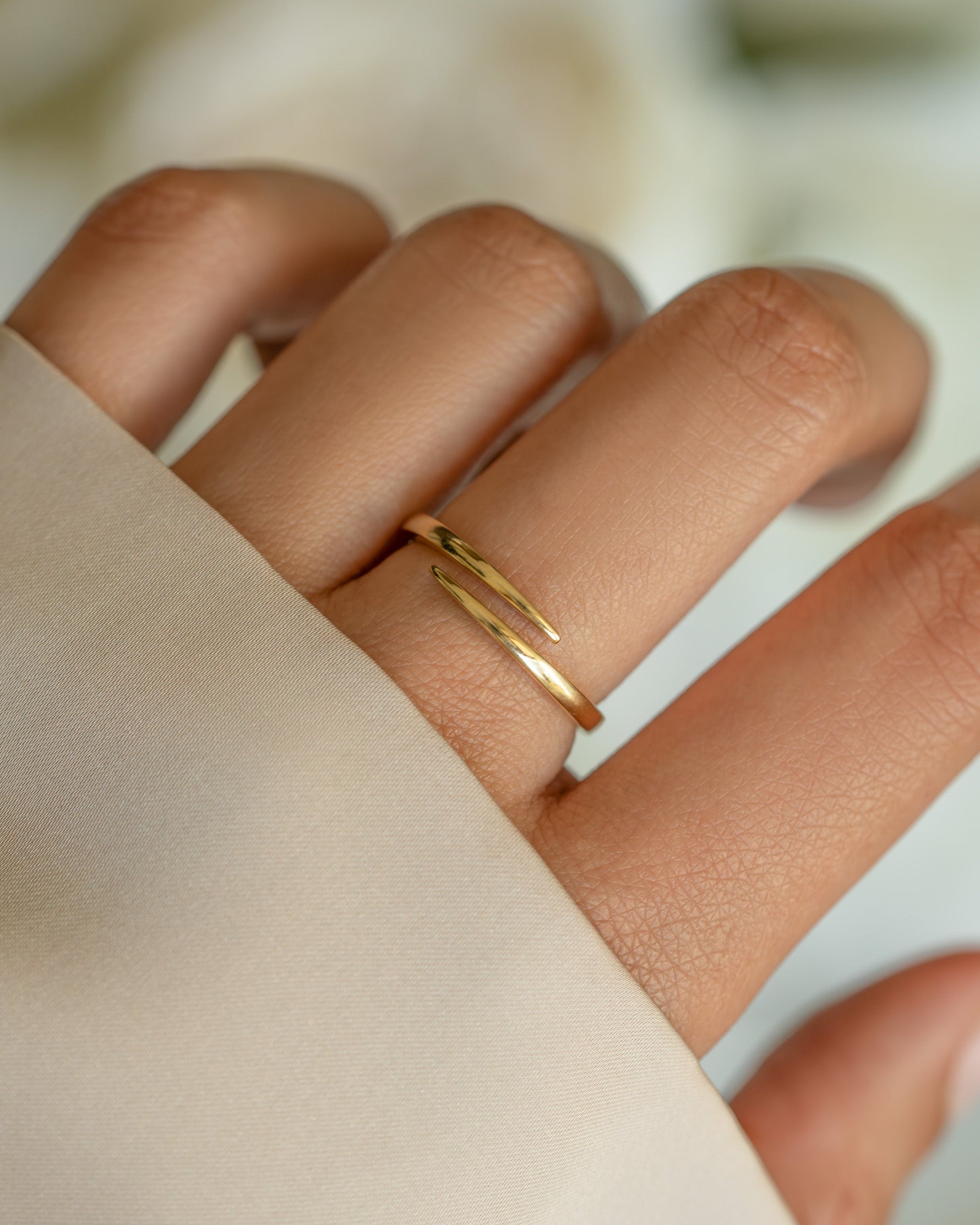 Gold open spiral ring from Sami Jewels featuring a sleek, minimalist design on a model's finger.
