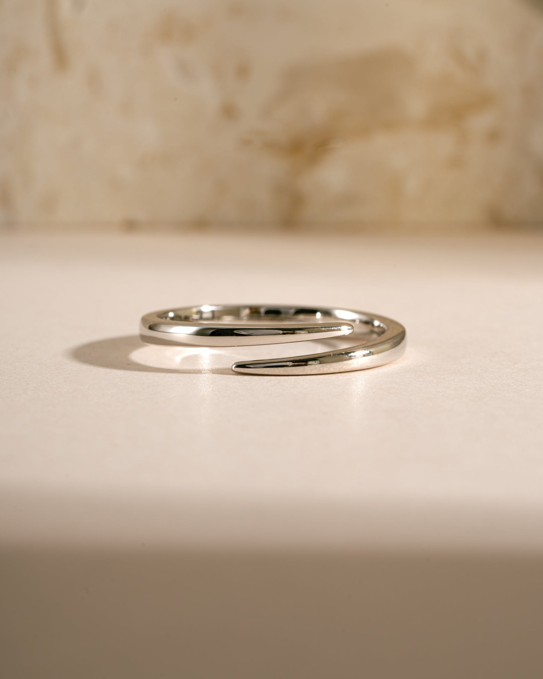 Close-up of a sterling silver open spiral ring by Sami Jewels, showcasing its elegant, curved design and polished finish.