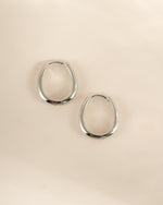 Sterling silver oval hoop earrings by Sami Jewels, shown in a side profile view highlighting their smooth, polished finish.