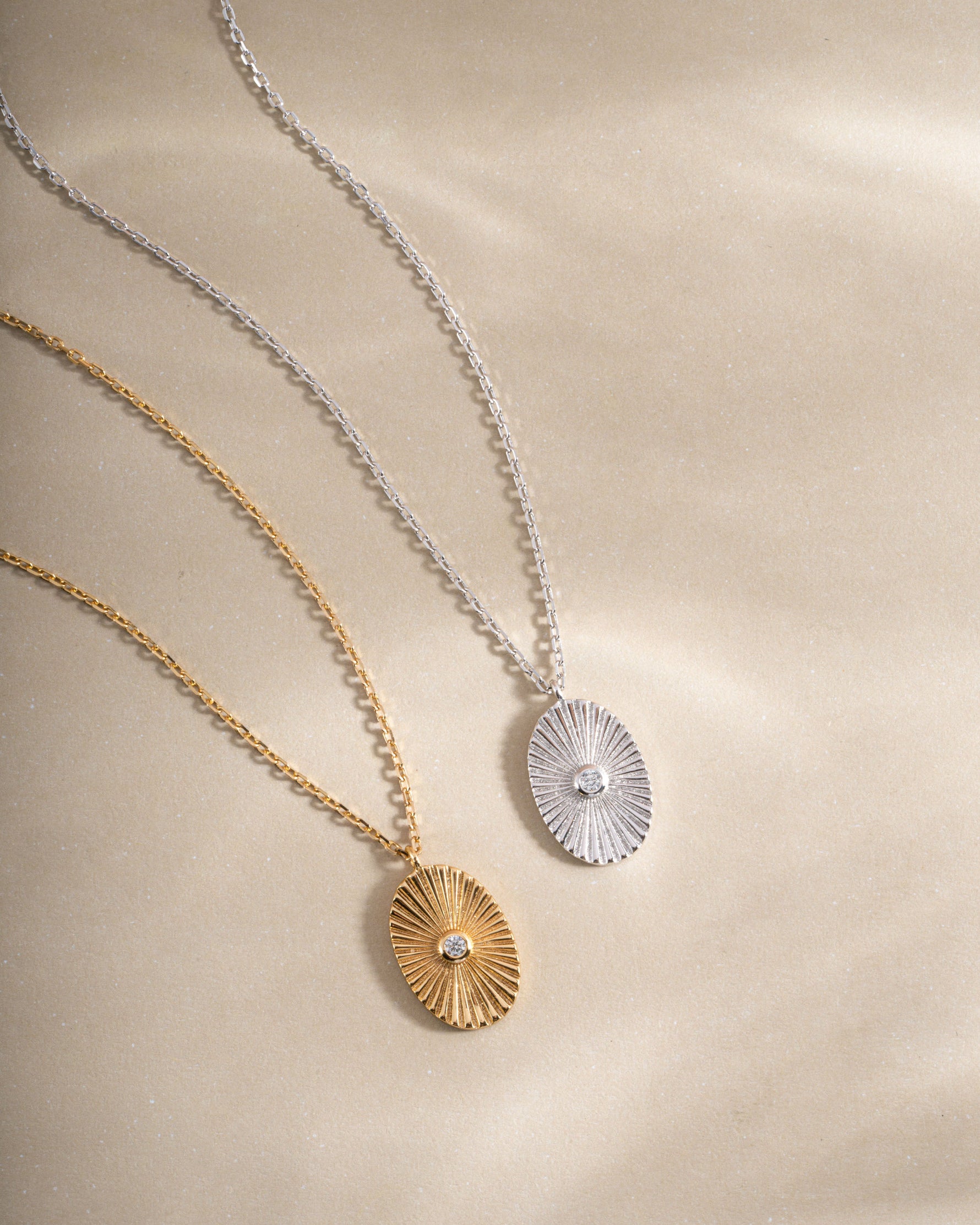 Gold and sterling silver oval medallion necklace by Sami Jewels featuring a detailed engraved pendant on a chain.