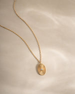 Gold oval medallion necklace from Sami Jewels featuring a polished pendant on a delicate chain.
