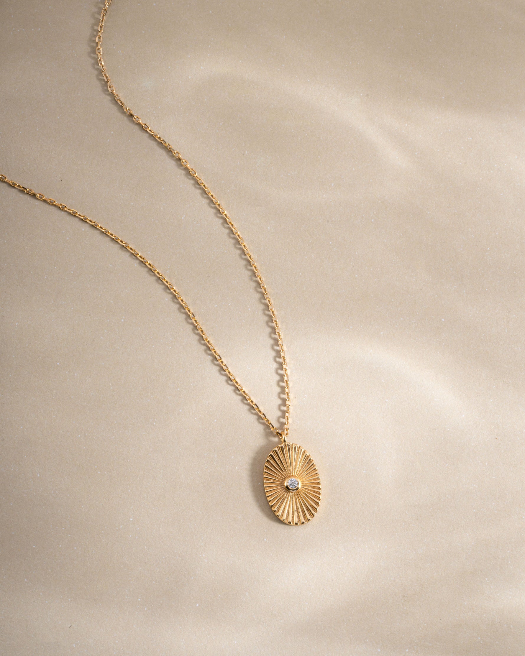 Gold oval medallion necklace from Sami Jewels featuring a polished pendant on a delicate chain.