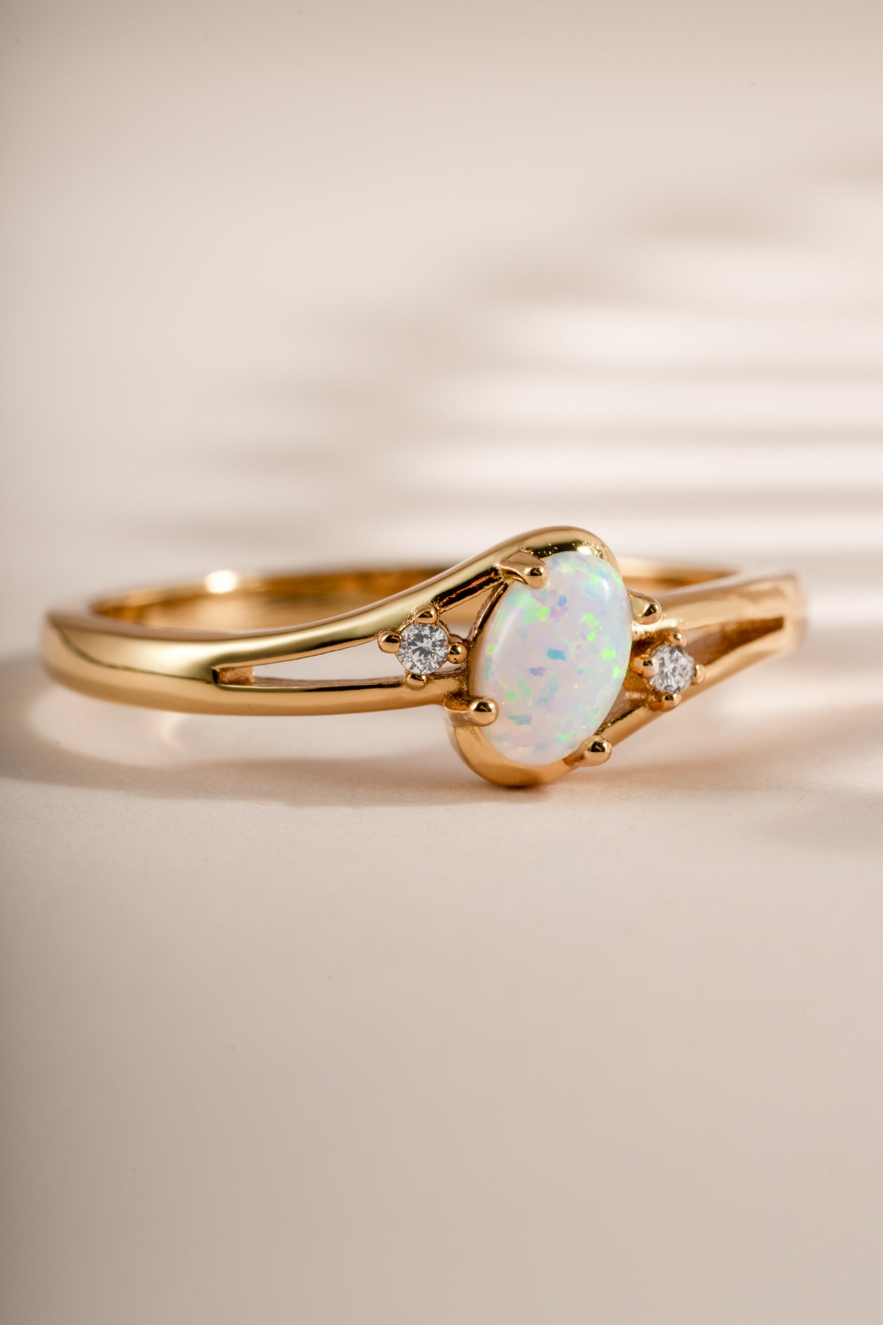 Close-up of a Sami Jewels small oval opal ring featuring a vibrant oval opal stone set in gold.
