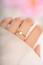 Small oval opal ring by Sami Jewels featuring a gold band and a vibrant oval opal gemstone.