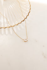 Close-up of Sami Jewels gold oval pendant necklace showcasing its elegant design and polished finish.