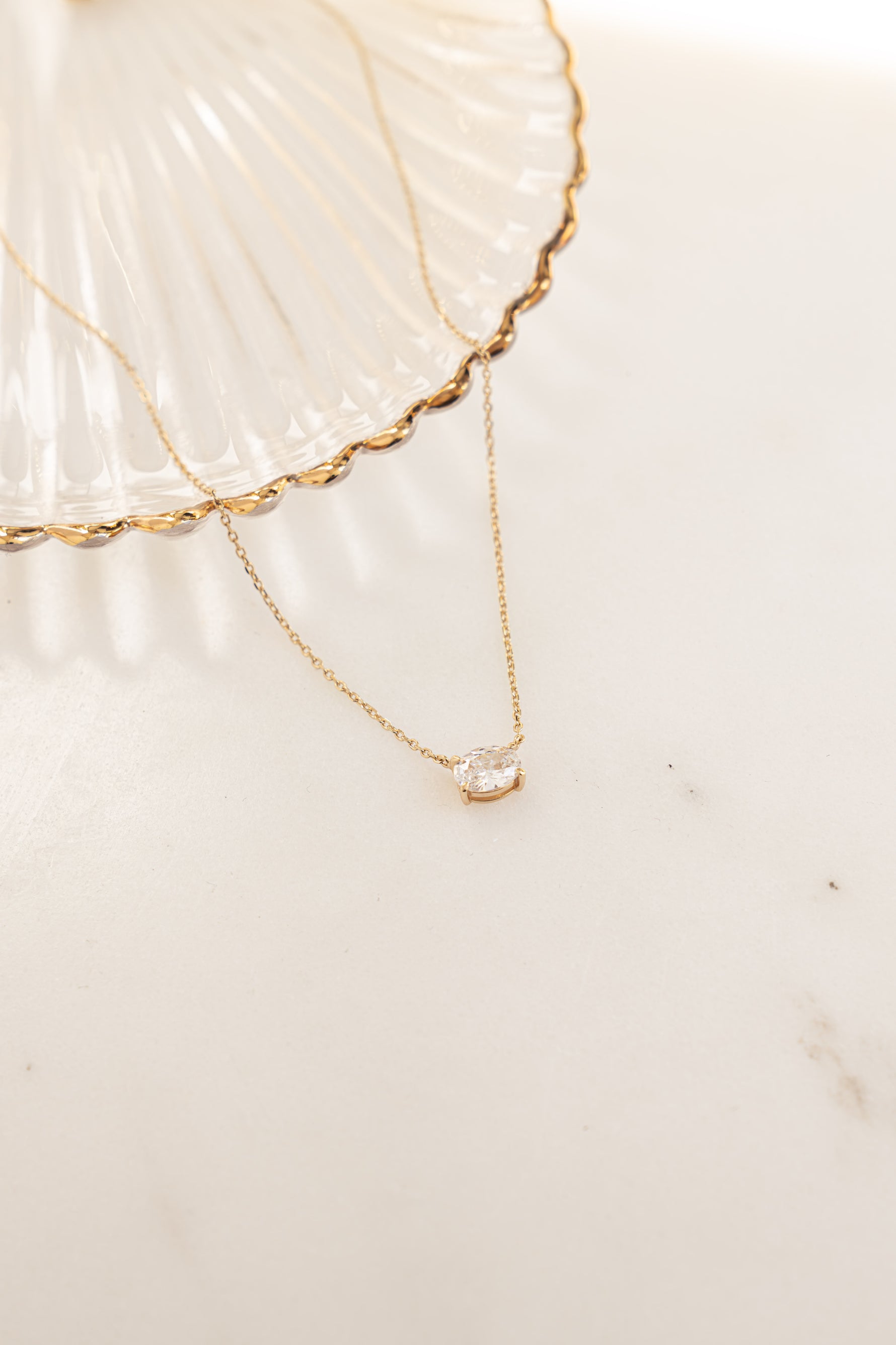 Close-up of Sami Jewels gold oval pendant necklace showcasing its elegant design and polished finish.