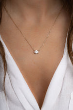 Gold oval pendant necklace from Sami Jewels, featuring a sleek and elegant design, worn by a model.