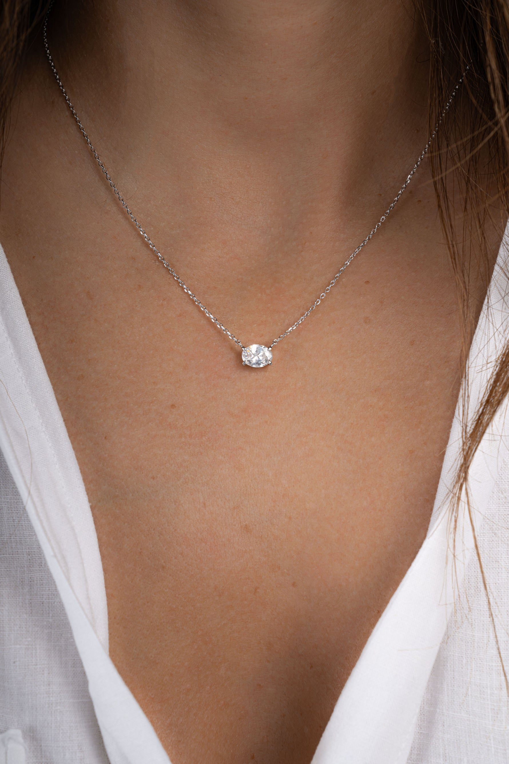 Sterling silver oval pendant necklace from Sami Jewels featuring a sleek, polished design worn by a model.