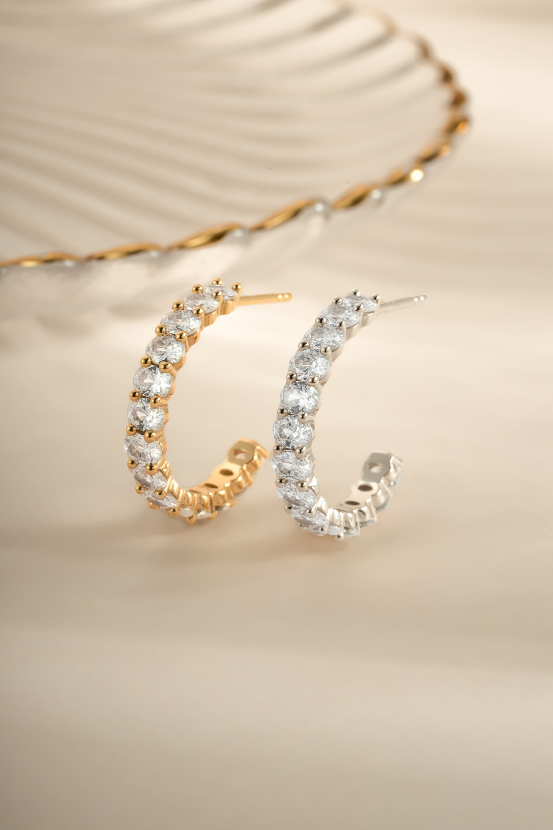 Gold and sterling silver oval studded hoop earrings by Sami Jewels featuring intricate stone details and classic hoop design.