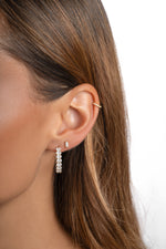 Gold oval studded hoop earrings from Sami Jewels featuring a sleek hoop design with embedded stones.