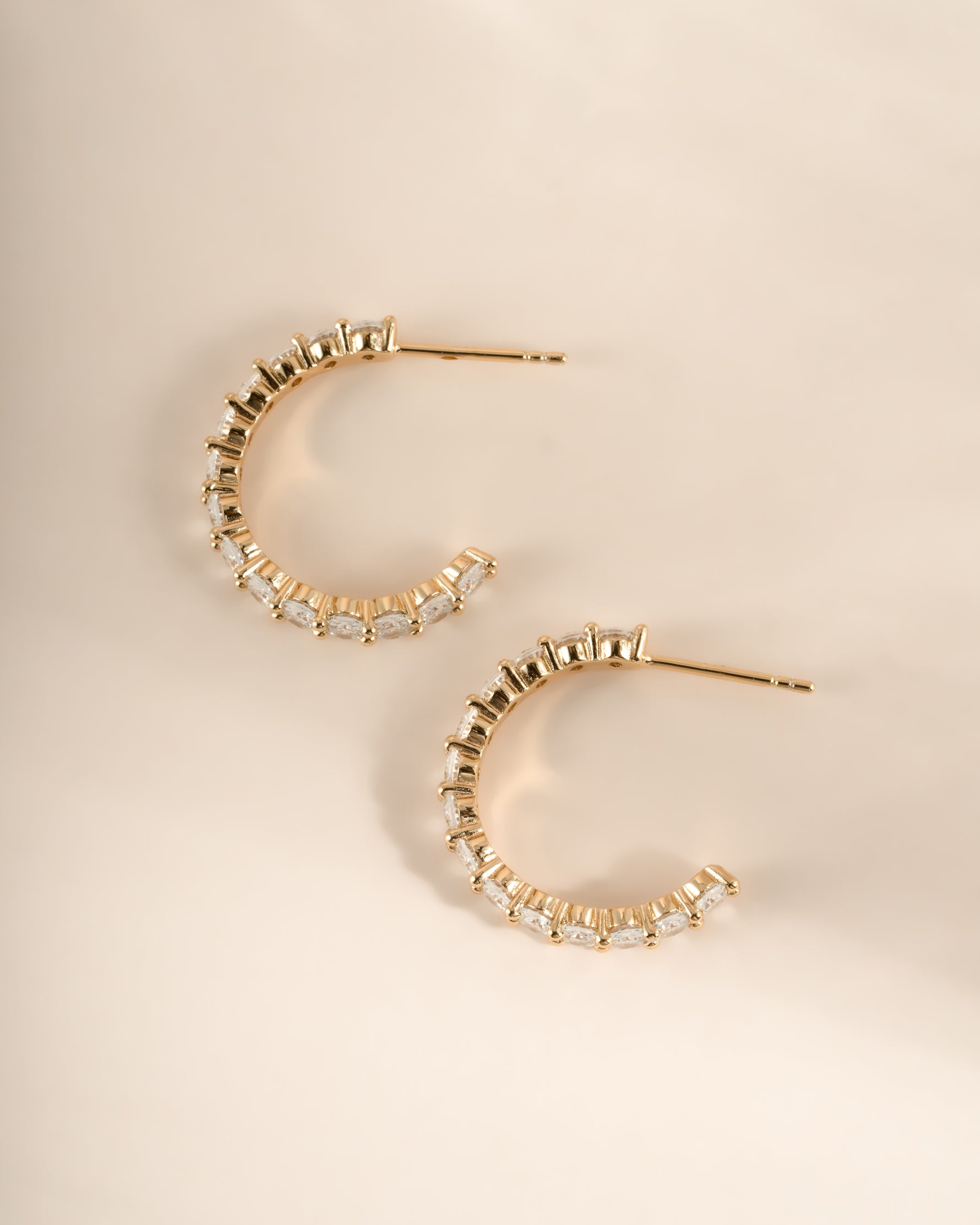 Gold oval studded hoop earrings by Sami Jewels, side profile showing textured surface and classic hoop shape.