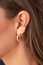 Gold oval studded hoop earrings from Sami Jewels styled on a model, showcasing their elegant design and textured details.