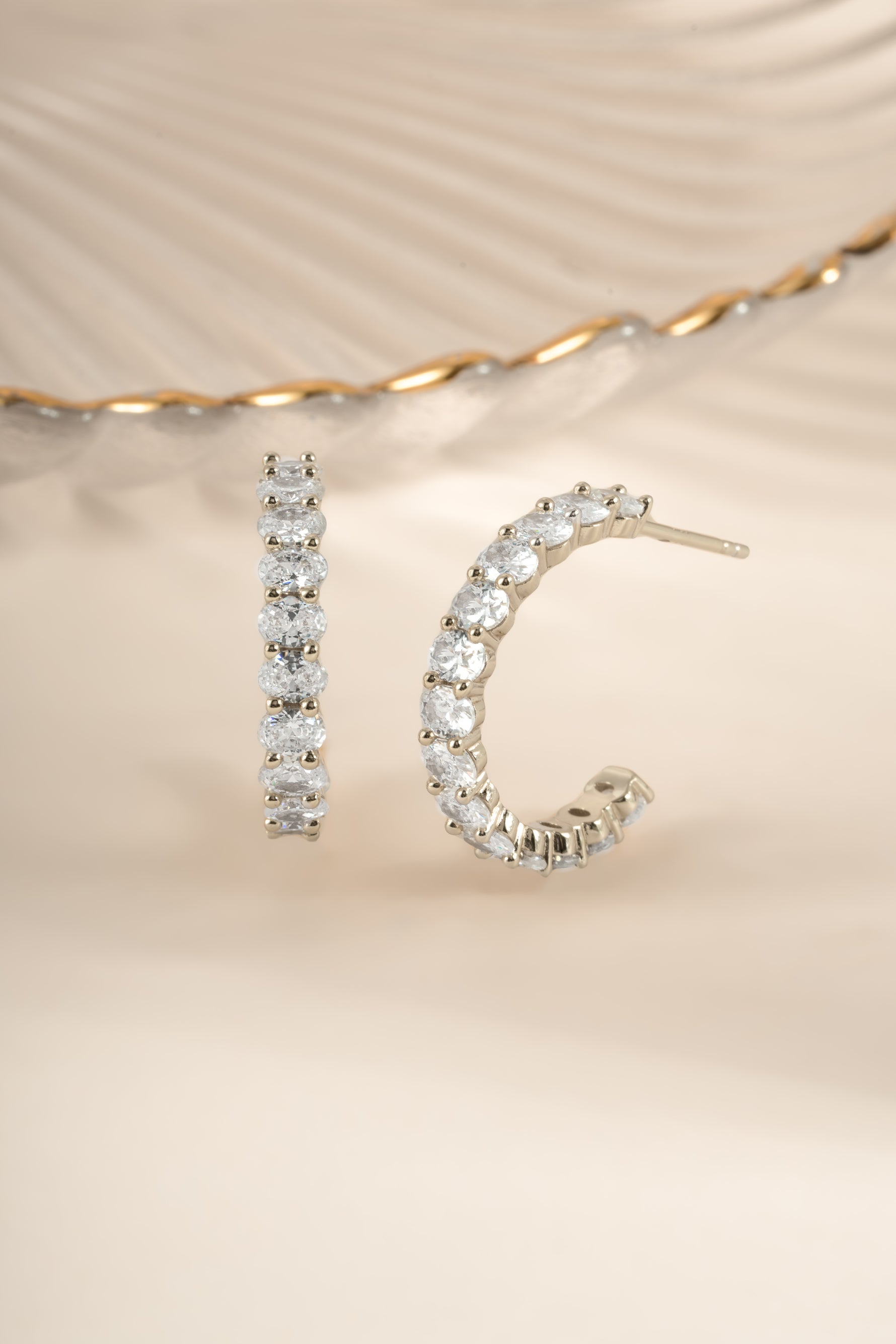 Sterling silver oval studded hoop earrings by Sami Jewels, featuring embedded stones and a sleek hoop design.