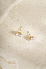 Gold 4x6mm oval studs from above, showing their posts and open four-prong settings.